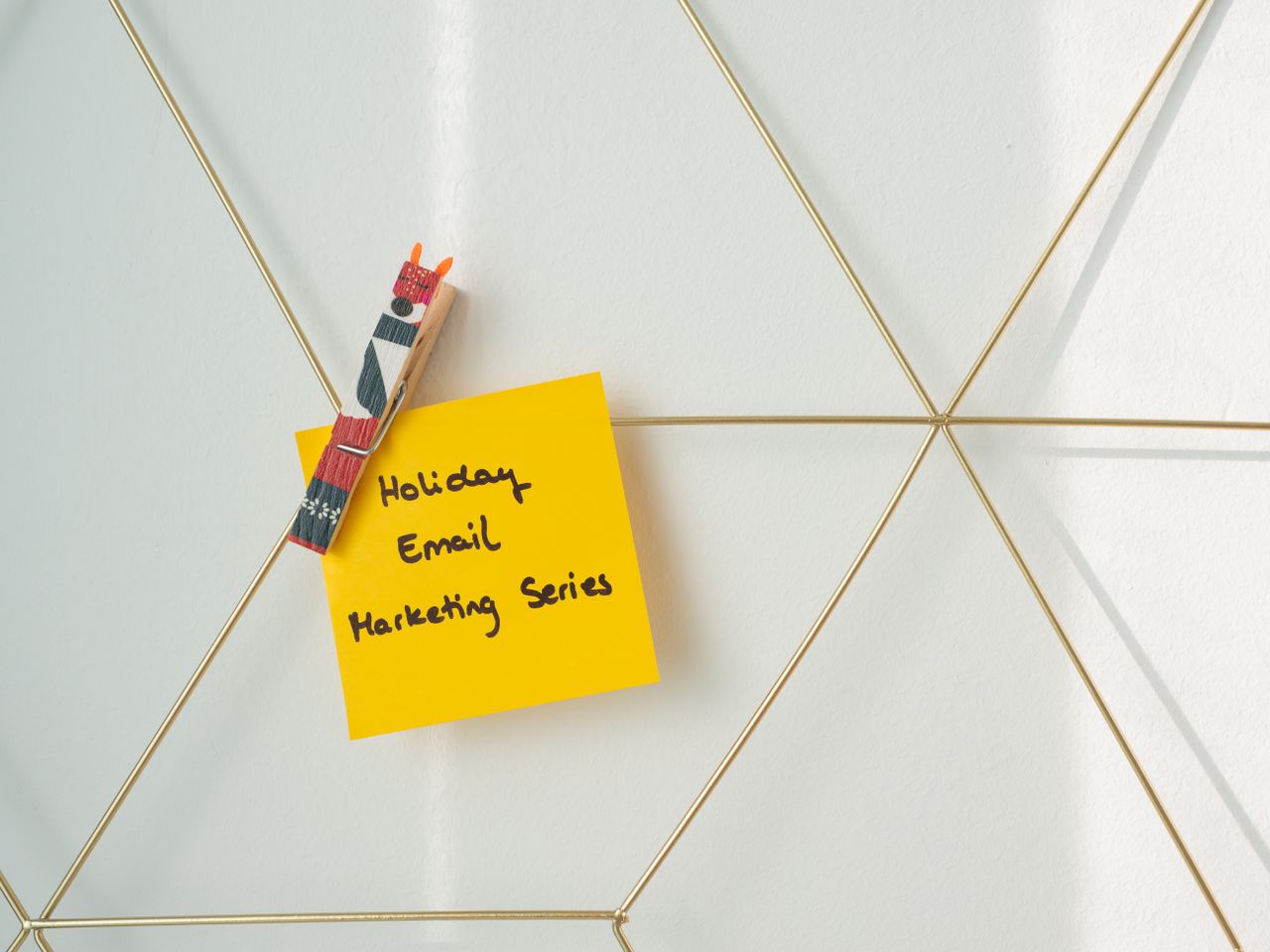 services-02 Bright yellow sticky note with holiday email marketing message clipped to a wireframe wall.